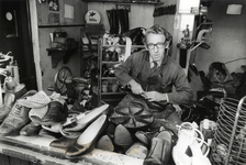 404234 Portret van schoenmaker W.J. van Soest in zijn werkplaats (Koningin Julianastraat 7) te Houten.